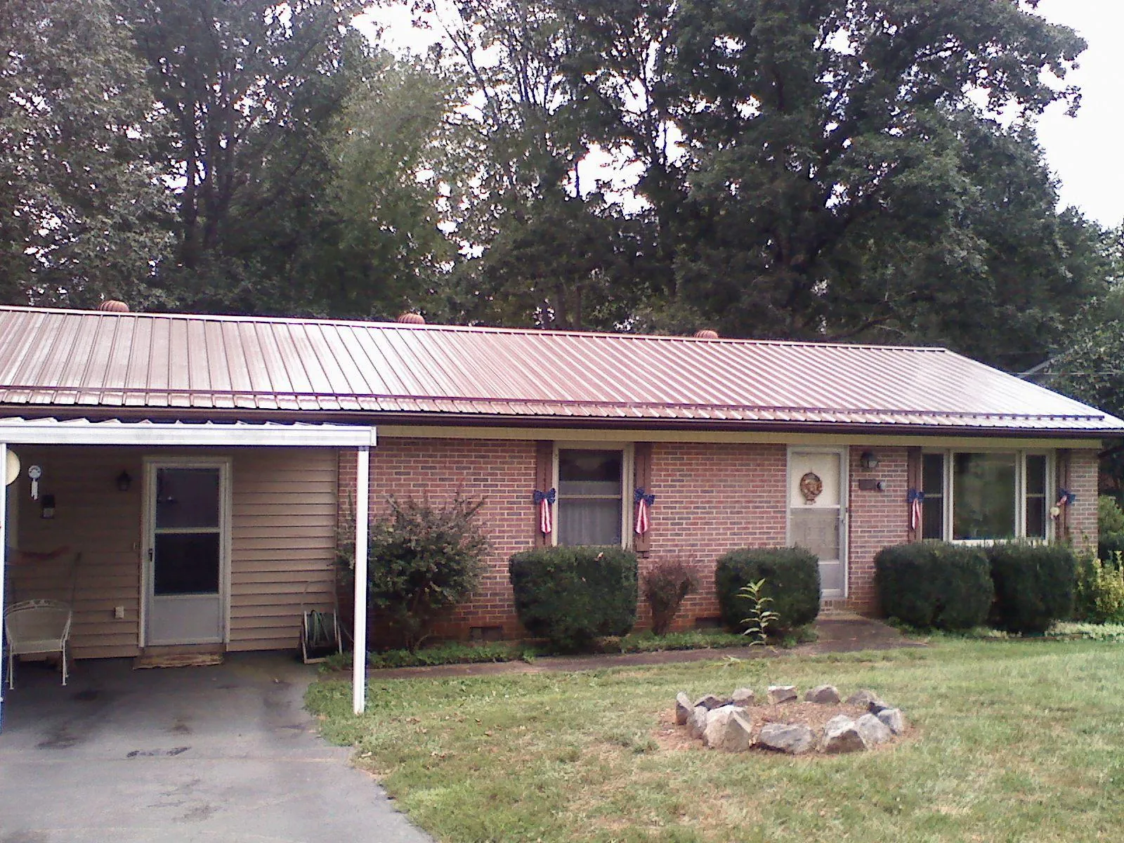 Bronze metal roof and carport on a brick ranch home — Roof Repair work by our crew in Courtland
